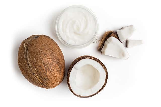 A Cup of Creamed coconut and a coconut in a white background